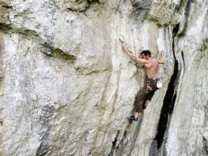 Traditional rock climbing on natural rock faces using ropes, harnesses, and anchors.